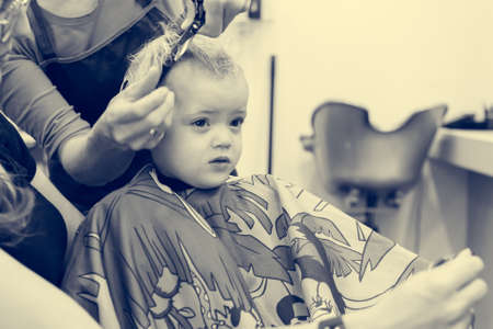 Cute blonde girl having her first haircut.の写真素材