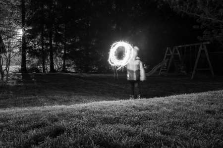 Child light painitng with christmas sparklers outside.の写真素材