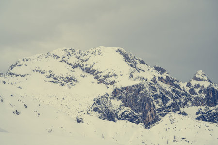 Spectacular winter mountain panoramic view of mountains with clouded sky.