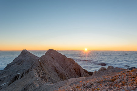 Spectacular morning mountain panorama with sun raising above sea of clouds.の写真素材