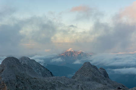 Spectacular mountain view with evening clouds rolling over peaks and ridges.の写真素材