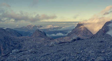 Spectacular mountain view with evening clouds rolling over peaks and ridges.の写真素材