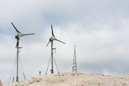 Wind power generators positioned on mountain ridge for zero impact mountaineering tourism.