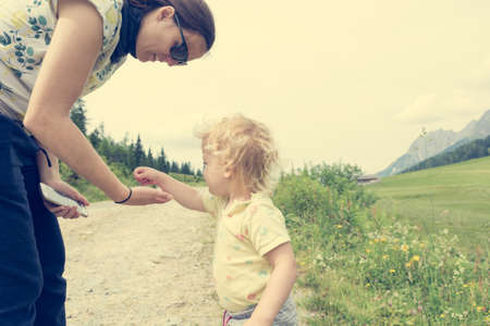 Mother and cute daughter exploring mountain pastures.の写真素材