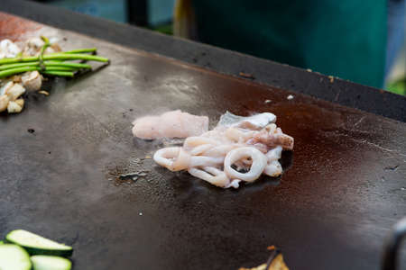 Cheff preparing traditional Mediterranean squid dish on a hot grill.の写真素材