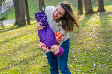 Happy father playing with his baby daughter in a park.