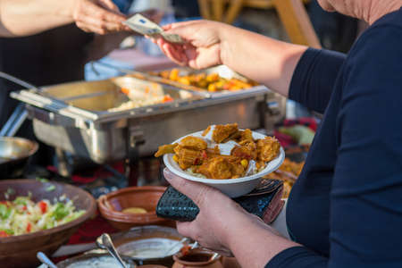 Customer paying for a dish on outdoor food stand.の写真素材