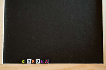 Corona written with alphabet beads on black board.の写真素材
