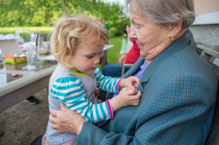 Grandmother having her grandaughter in lap and talking.