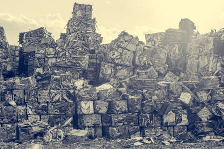 Compressed aluminium scrap in large cubes forming landfill in piles. Reusing and recycling waste material.の写真素材