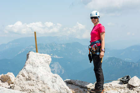 Female climber posing on top of a mountain.の写真素材