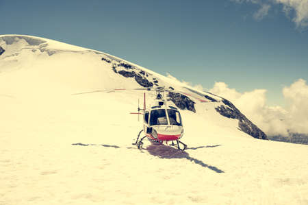 White and red helicopter landed on snow in winter.の写真素材
