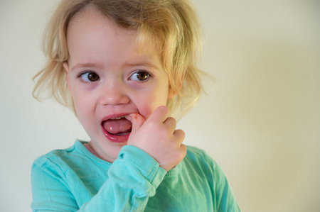 Portrait of cute blonde girl showing her teeth.