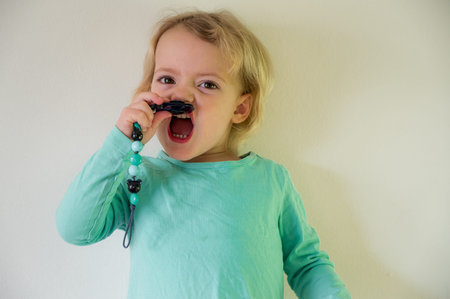 Portrait of cute blonde girl wearing cyan shirt having fun.