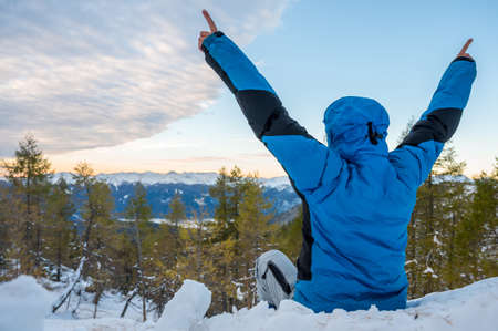 Rear view of mountaineer celebrating a dawn of new day.の写真素材