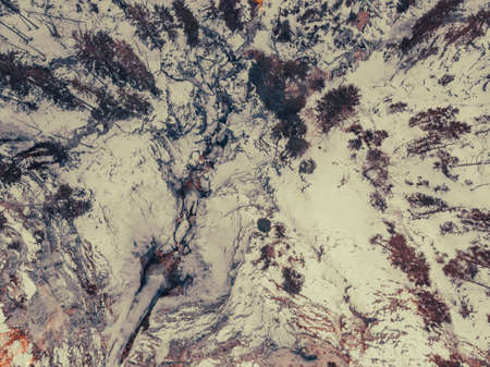 Spectacular drop down view of waterfall falling over rocky forest ledge.の写真素材