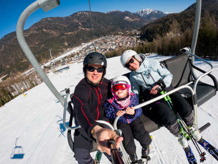 Happy young family taking a selfie at skiing resort.の写真素材
