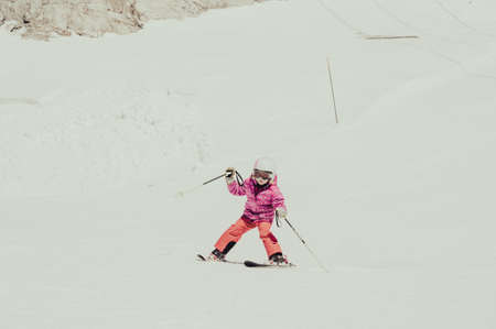Cute young girl learning to skii at winter resort on a sunny day.の写真素材