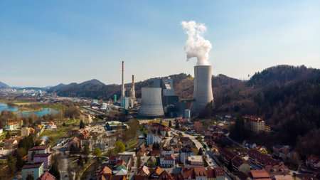 Latest generation thermal power plant with chimneys and cooling tower producing clean energy.の写真素材