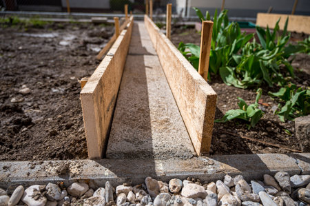 Building a concrete path through vegetable garden using wooden planks.の写真素材