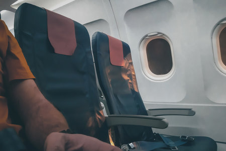 Empty row of seats on a plane next to mine. Happy moment when there is noone seating next to you on a flight. Lonely flight with a planeの写真素材