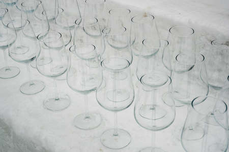 Wine glasses standing in pattern on snow or ice block. Glasses on a snowy surface, like a snow bar. Snow bar concept.の写真素材