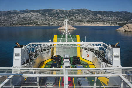 On board the car ferry in croatia, serving between island of Pag and mainland. Vehicles seen in the ferry hold waiting to reach the shore in sunny summer afternoon.の写真素材