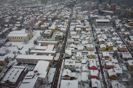 Morning aerial winter panorama of Siska, a suburban part of Ljubljana, capital of Slovenia, with the church and other bigger houses visible. Hazy cold winter weather in Ljubljana some snow on the rooftops.の写真素材