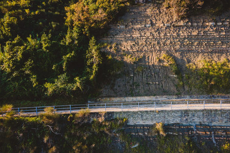 Pedestrian walkway on the edge of a cliff, guarded by metal handrail.