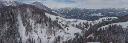 Aerial drone panorama of snow covered mountains around Davca and Zelezniki in Gorenjska region of Slovenia on a cloudy winter day.の写真素材