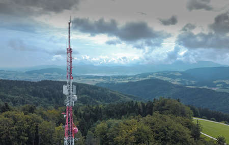 Big antenna mast for 3G, 4G and 5G repeater in the middle of the forest or nature. Controversial tehnology in the wild nature. Panoramic view.の写真素材