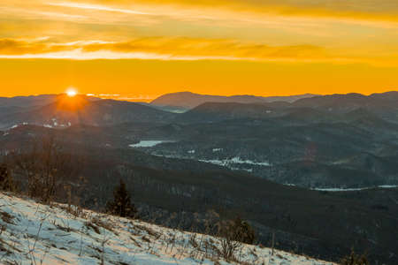 Early morning view from Slivnica hill above Cerknica, just at sunrise. Visible beautiful snow covered mountains in the distance.の写真素材