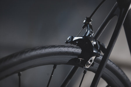 Detail of the rear brake and frame of a road bicycle on a silky black background.の写真素材