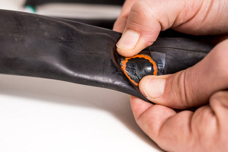Bicycle inner tube repair. A person is applying vulcanization patch on inner tube in order to fix the puncture of the inner tube.の写真素材