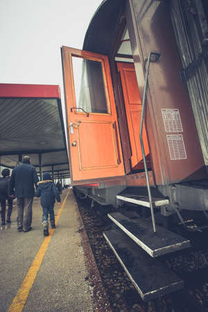 A kid and his parent have exited an old vintage train coach on a platform. View of the stairs.の写真素材
