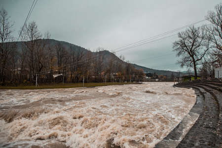 Wild dirty brown river just after heavy rainfall in autumn.の写真素材