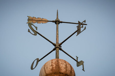 Weather vane with arrow on a rooftop, on the top of the lighthouse on Santiago in the city of Praia,...