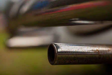 Rusty and chromed exhaust. Exhaust pipe in chrome finish, but already showing signs of rust and decay.の写真素材
