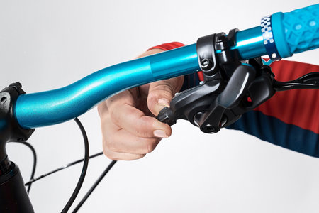 Bicicle repair or maintenance. Adjustment of rear deraileur or gear changer with a collar or adjustment nut on the gear switch handle, by turning the knob clockwise or anticlockwise.の写真素材