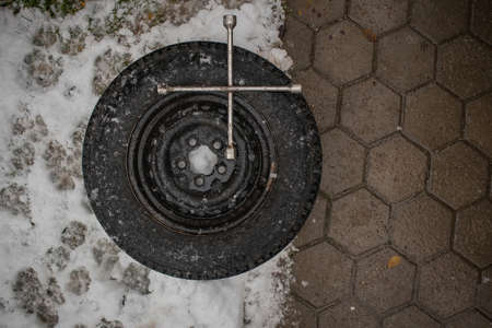 Time to change those tires! Car or suv wheel ready to be mounted on a car with a tyre wrench sitting on top, ready to be used.の写真素材