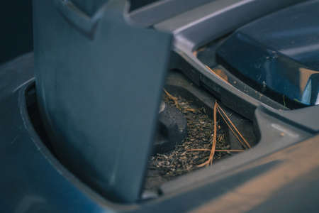 Dirty knob of robotic lawnmower, motorized lawnmower being serviced on a table after a year of use in the mud and grass. Regular maintenance of robotic lawnmowerの写真素材