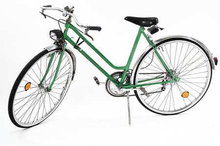 An old retro looking green vintage city bicycle for women, isolated o white background. Side viewの写真素材