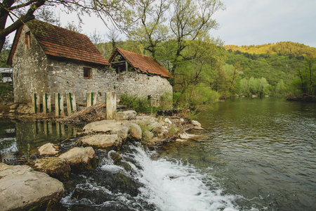 A small stone dam and an abandoned mill on Kolpa river, Slovenia.の写真素材