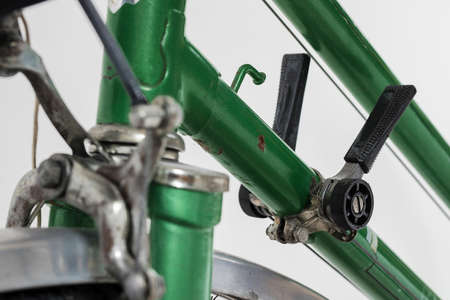 An old retro looking green vintage city bicycle for women, isolated o white background. Detail of old style gear shift mechanism. Gear shift  levers out of plastic.の写真素材