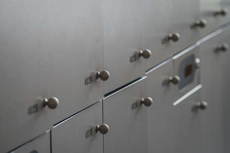 Close up of many lockers or metal or wooden lock boxes. Lockers with numbers, rfid codes and round knobs.の写真素材