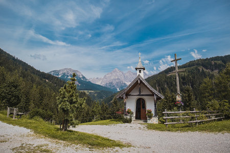Beautiful Mandlberg kapelle or chapel in the austrian Tauern alps close to Mandling in front of breathtaking view of Dachstein glacier on a hot summer day.の写真素材