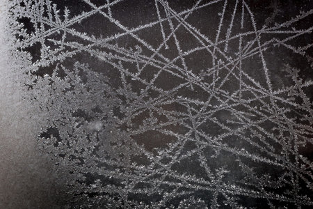 Frost pattern on glass of a window. Frozen ice forming during the cold weather on glass window....