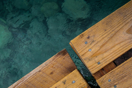 Wooden planks or boards on a pier over a tourquoise sea under the bords. Wooden boards over water...