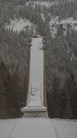 Old deserted or abandoned famous ski jumping hill in Cortina d'Ampezzo, Italy on a winter day with snow.の写真素材