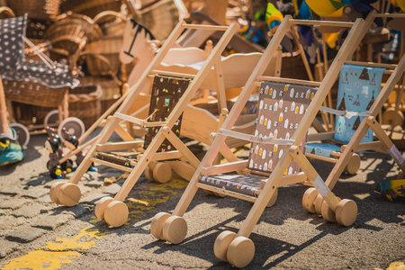 Wooden pram as a kids toy on a display at a country fair. Object to buy on a fair or market, wooden...